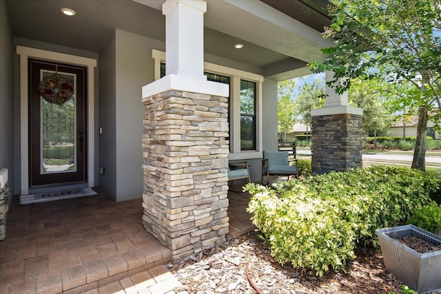 12415 Hitching St, Odessa, FL 33556 - view of exterior entry featuring stucco siding, covered porch, and stone siding