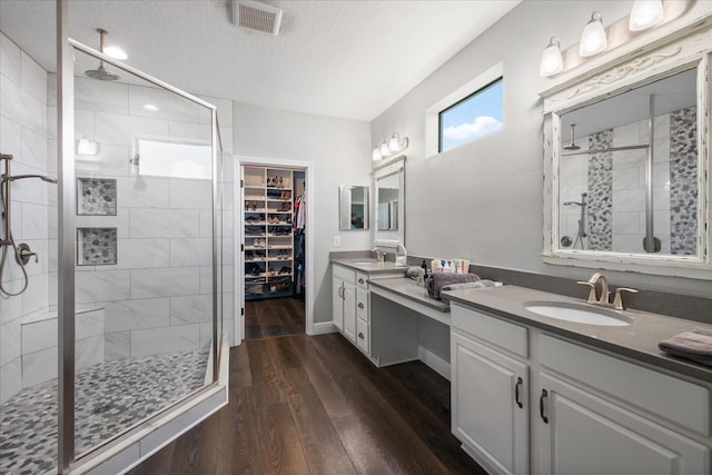12415 Hitching St, Odessa, FL 33556 - full bath with a shower stall, vanity, wood finished floors, a textured ceiling, and a walk in closet