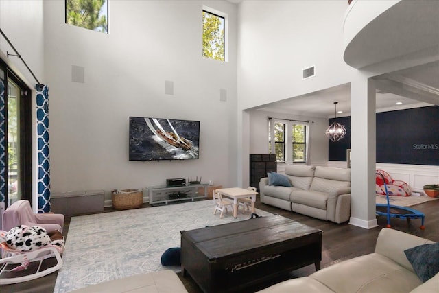 12415 Hitching St, Odessa, FL 33556 - living room with a towering ceiling, wood finished floors, a chandelier, wainscoting, and a decorative wall