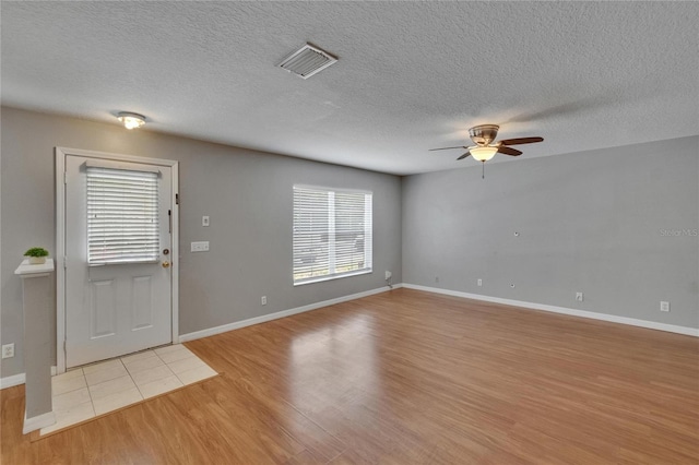 3455 Castle Stone Ct, Valrico, FL 33594 - foyer entrance with ceiling fan, light wood-style flooring, and a textured ceiling