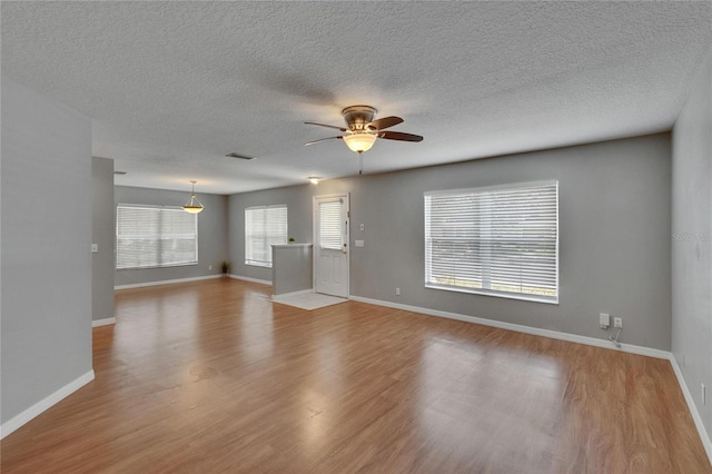 3455 Castle Stone Ct, Valrico, FL 33594 - unfurnished living room featuring ceiling fan, wood finished floors, and a textured ceiling