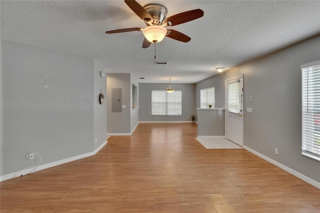 3455 Castle Stone Ct, Valrico, FL 33594 - empty room featuring a textured ceiling, light wood-type flooring, a ceiling fan, and electric panel