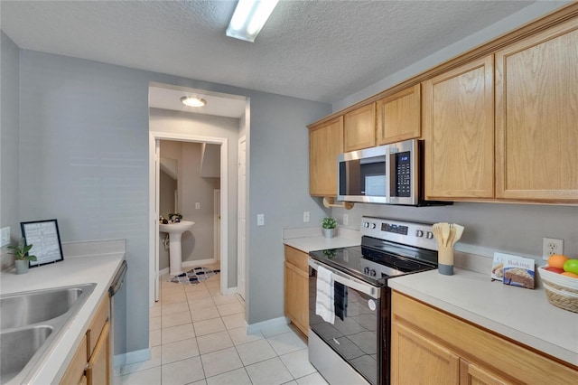 3455 Castle Stone Ct, Valrico, FL 33594 - kitchen with appliances with stainless steel finishes, light tile patterned floors, light brown cabinets, light countertops, and a textured ceiling