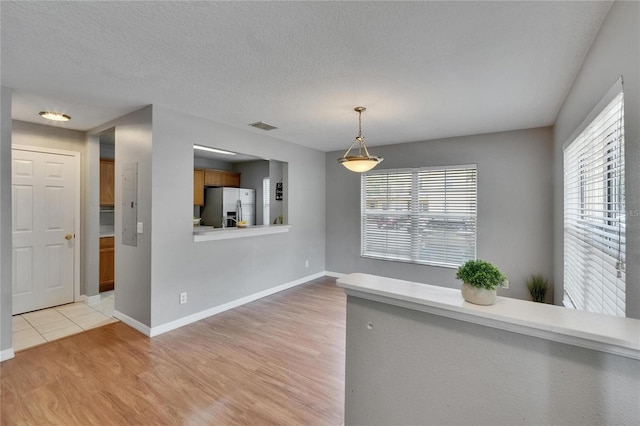 3455 Castle Stone Ct, Valrico, FL 33594 - unfurnished dining area featuring light wood-style floors and a textured ceiling