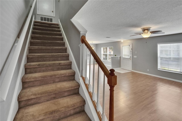 3455 Castle Stone Ct, Valrico, FL 33594 - staircase with a ceiling fan, a textured ceiling, and wood finished floors