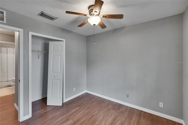 3455 Castle Stone Ct, Valrico, FL 33594 - unfurnished bedroom with wood finished floors, a closet, a textured ceiling, and ceiling fan