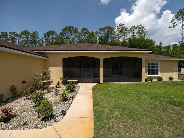 21590 SW 84th Loop, Dunnellon, FL 34431 - back of house with stucco siding, a sunroom, a yard, and a shingled roof
