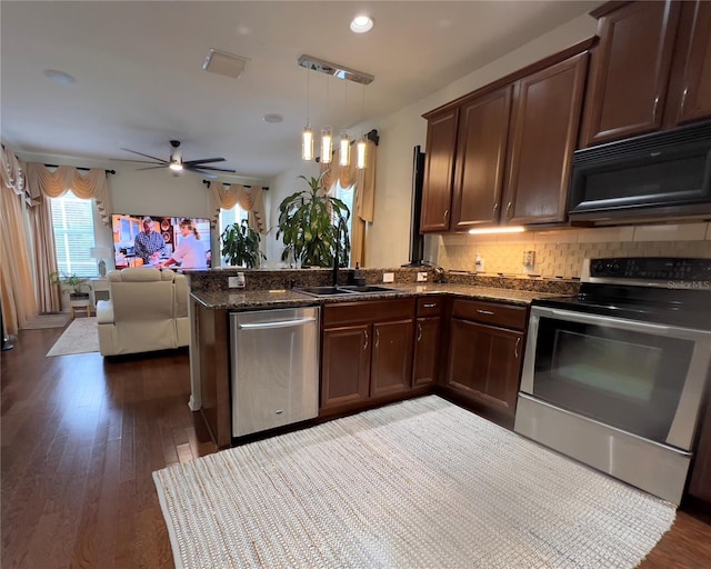 1247 Gentilly Ln, Wesley Chapel, FL 33544 - kitchen featuring stainless steel appliances, a peninsula, a ceiling fan, open floor plan, and decorative backsplash