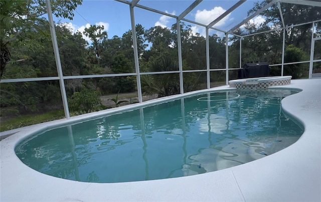 1247 Gentilly Ln, Wesley Chapel, FL 33544 - view of swimming pool featuring glass enclosure and a pool with connected hot tub