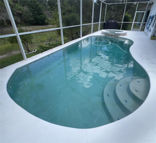 1247 Gentilly Ln, Wesley Chapel, FL 33544 - outdoor pool featuring an in-ground hot tub, glass enclosure, and a patio area