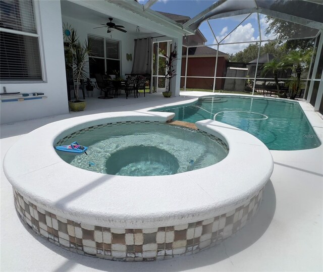 1247 Gentilly Ln, Wesley Chapel, FL 33544 - view of swimming pool featuring a ceiling fan, a patio area, a pool with connected hot tub, a storage unit, and a lanai