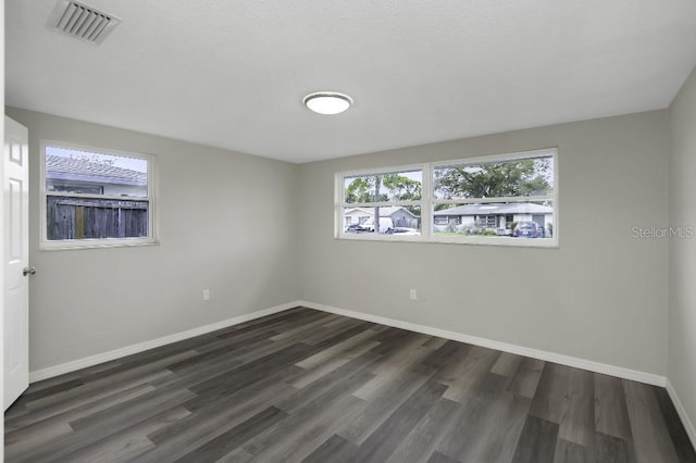 7625 Marechal Ave, Port Richey, FL 34668 - spare room with baseboards and dark wood-style flooring
