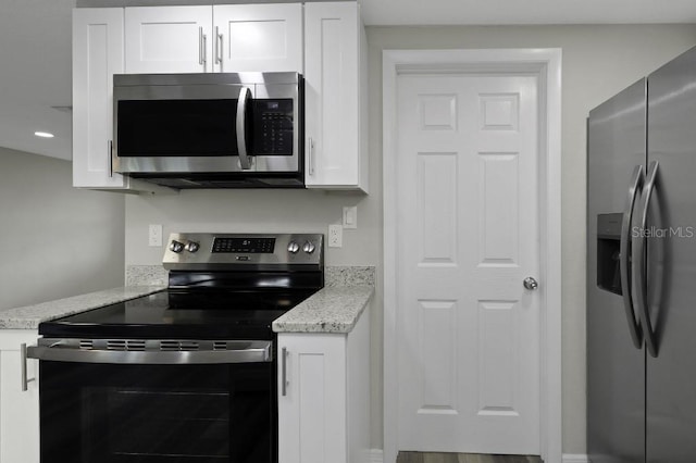7625 Marechal Ave, Port Richey, FL 34668 - kitchen featuring appliances with stainless steel finishes, white cabinetry, and light stone counters