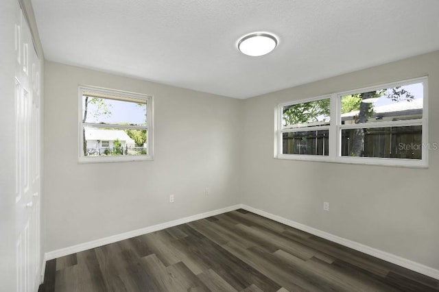 7625 Marechal Ave, Port Richey, FL 34668 - unfurnished bedroom with baseboards and dark wood-style flooring