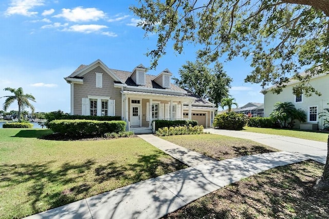 5205 Brighton Shore Dr, Apollo Beach, FL 33572 - view of front of house featuring an attached garage, driveway, a front lawn, and covered porch