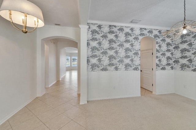 5205 Brighton Shore Dr, Apollo Beach, FL 33572 - spare room with arched walkways, crown molding, a wainscoted wall, light tile patterned floors, and a chandelier