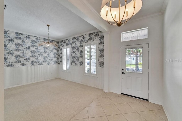 5205 Brighton Shore Dr, Apollo Beach, FL 33572 - foyer entrance with a chandelier, a wainscoted wall, ornamental molding, light tile patterned floors, and light carpet