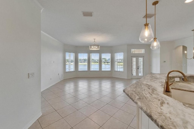 5205 Brighton Shore Dr, Apollo Beach, FL 33572 - kitchen featuring crown molding, light tile patterned floors, a chandelier, arched walkways, and decorative light fixtures