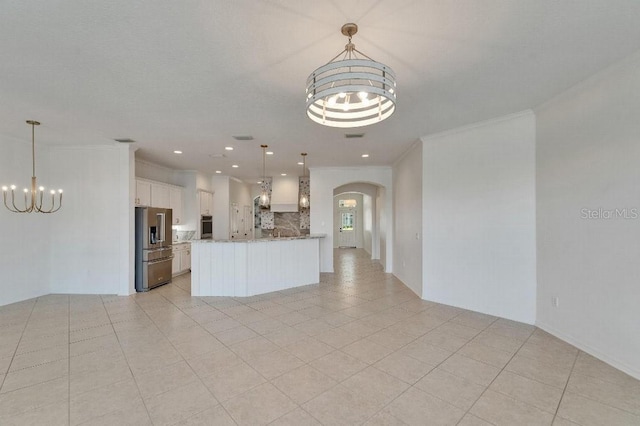 5205 Brighton Shore Dr, Apollo Beach, FL 33572 - kitchen featuring a chandelier, stainless steel appliances, arched walkways, open floor plan, and white cabinets
