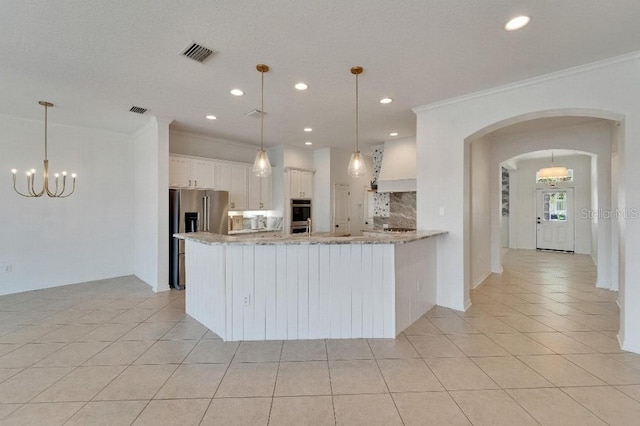 5205 Brighton Shore Dr, Apollo Beach, FL 33572 - kitchen with stainless steel appliances, ornamental molding, arched walkways, light tile patterned floors, and premium range hood