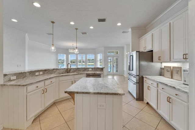 5205 Brighton Shore Dr, Apollo Beach, FL 33572 - kitchen with a center island, recessed lighting, white cabinets, appliances with stainless steel finishes, and light tile patterned flooring