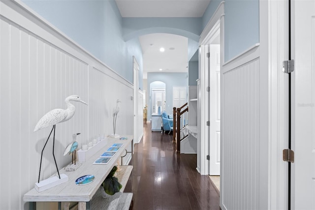 511 Winterside Dr, Apollo Beach, FL 33572 - corridor with arched walkways, dark wood-type flooring, a decorative wall, a wainscoted wall, and stairs