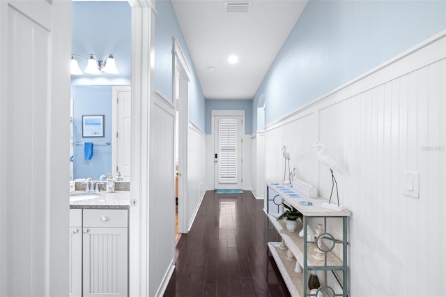 511 Winterside Dr, Apollo Beach, FL 33572 - hallway featuring wainscoting, dark wood-type flooring, and a decorative wall