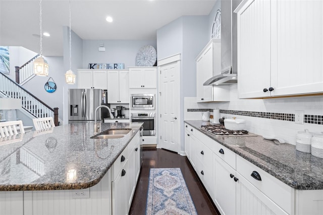 511 Winterside Dr, Apollo Beach, FL 33572 - kitchen with appliances with stainless steel finishes, dark wood finished floors, tasteful backsplash, white cabinets, and a spacious island