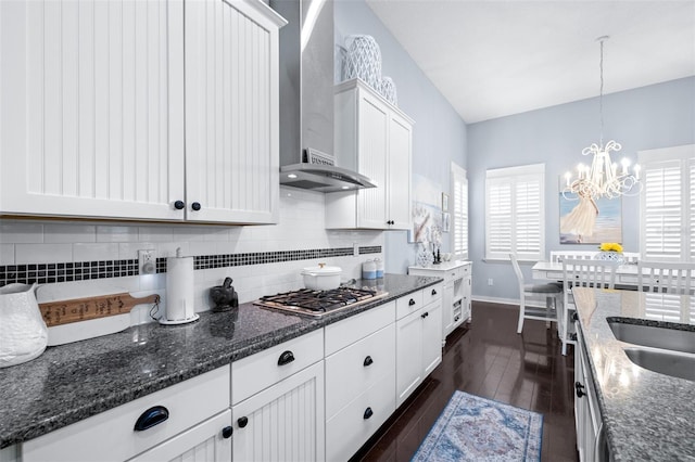 511 Winterside Dr, Apollo Beach, FL 33572 - kitchen with stainless steel gas stovetop, wall chimney exhaust hood, a chandelier, dark wood-style flooring, and white cabinetry