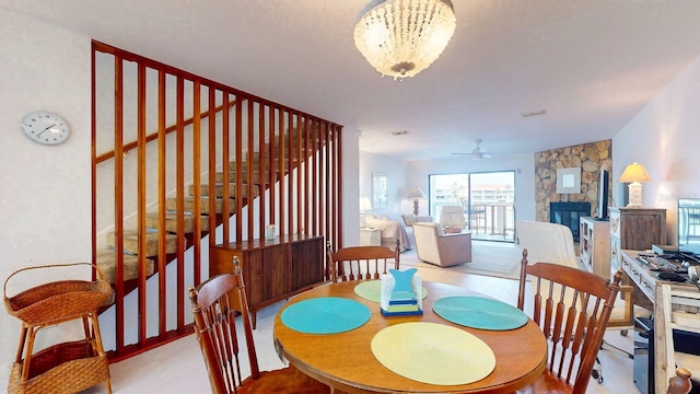 12132 Capri Cir S, Treasure Island, FL 33706 - dining room featuring ceiling fan, stairway, and a fireplace