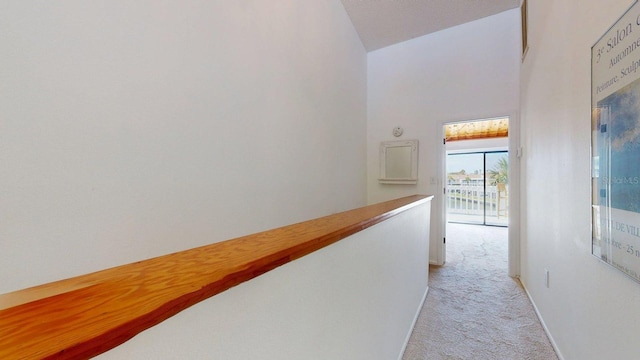 12132 Capri Cir S, Treasure Island, FL 33706 - corridor with light colored carpet and high vaulted ceiling