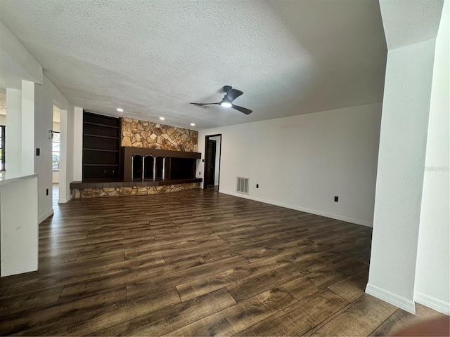 2102 Doefield Ct, Valrico, FL 33596 - unfurnished living room featuring a textured ceiling, dark wood finished floors, a stone fireplace, ceiling fan, and recessed lighting