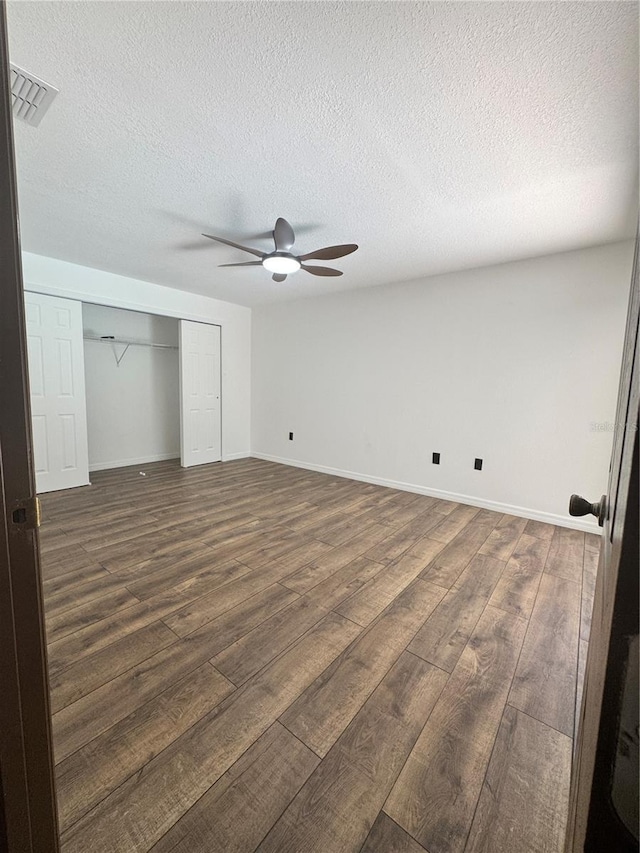 2102 Doefield Ct, Valrico, FL 33596 - unfurnished bedroom with dark wood-type flooring, a textured ceiling, a closet, and ceiling fan