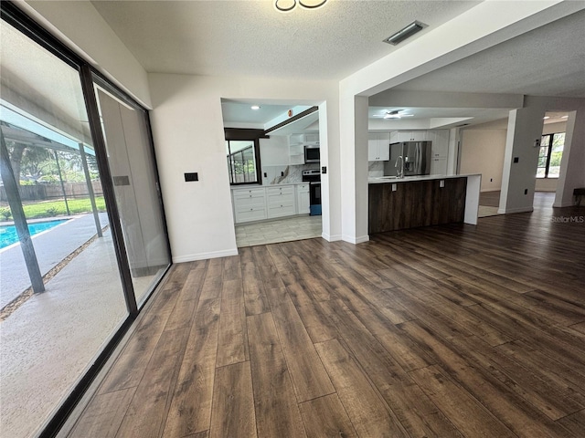 2102 Doefield Ct, Valrico, FL 33596 - unfurnished living room featuring dark wood-style flooring and a textured ceiling