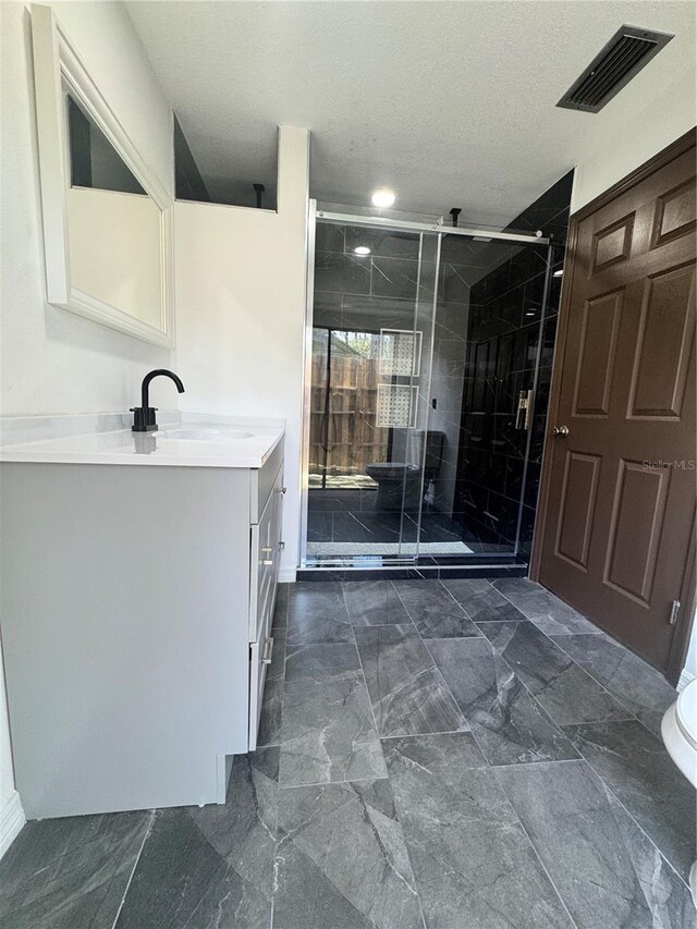 2102 Doefield Ct, Valrico, FL 33596 - bathroom featuring vanity, a stall shower, marble look tiles, and a textured ceiling