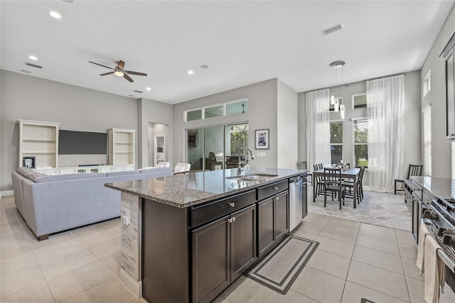 7114 Bowspirit Pl, Apollo Beach, FL 33572 - kitchen featuring stainless steel appliances, light tile patterned floors, light stone counters, an island with sink, and ceiling fan
