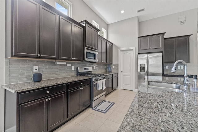 7114 Bowspirit Pl, Apollo Beach, FL 33572 - kitchen with appliances with stainless steel finishes, light stone countertops, decorative backsplash, light tile patterned floors, and healthy amount of natural light