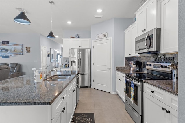 13301 Waterleaf Garden Cir, Riverview, FL 33579 - kitchen with appliances with stainless steel finishes, white cabinets, tasteful backsplash, light tile patterned floors, and recessed lighting