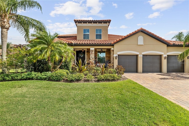165 Mobbly Bay Dr, Oldsmar, FL 34677 - mediterranean / spanish-style house with an attached garage, a front lawn, decorative driveway, stucco siding, and a tiled roof