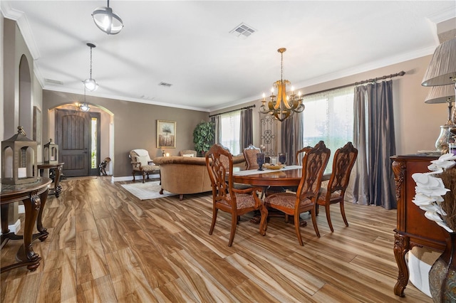165 Mobbly Bay Dr, Oldsmar, FL 34677 - dining space featuring arched walkways, light wood-type flooring, a chandelier, and ornamental molding