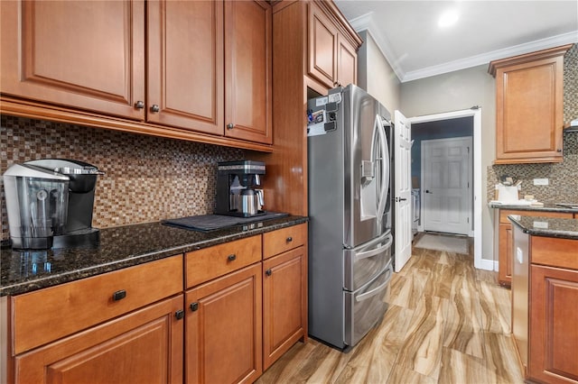 165 Mobbly Bay Dr, Oldsmar, FL 34677 - kitchen with stainless steel fridge, crown molding, brown cabinets, decorative backsplash, and dark stone counters
