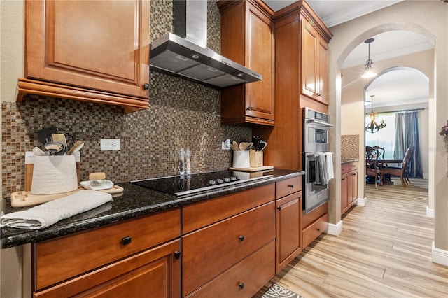 165 Mobbly Bay Dr, Oldsmar, FL 34677 - kitchen with wall chimney exhaust hood, black electric stovetop, crown molding, brown cabinetry, and arched walkways