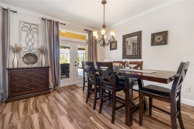 165 Mobbly Bay Dr, Oldsmar, FL 34677 - dining space with french doors, ornamental molding, a chandelier, and wood finished floors