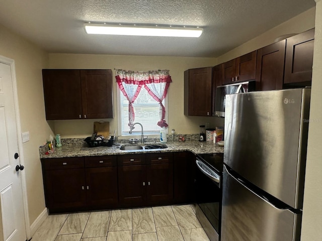 701 N 7th St, Haines City, FL 33844 - kitchen with appliances with stainless steel finishes, dark brown cabinets, a textured ceiling, and light stone countertops