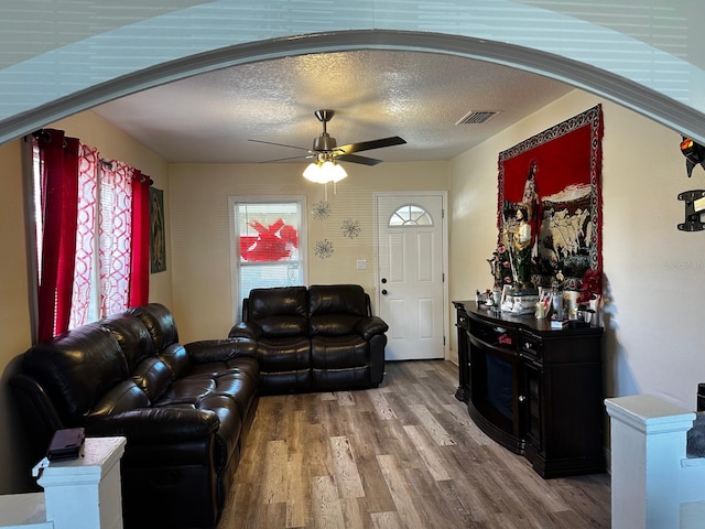701 N 7th St, Haines City, FL 33844 - living area with a ceiling fan, arched walkways, wood finished floors, and a textured ceiling