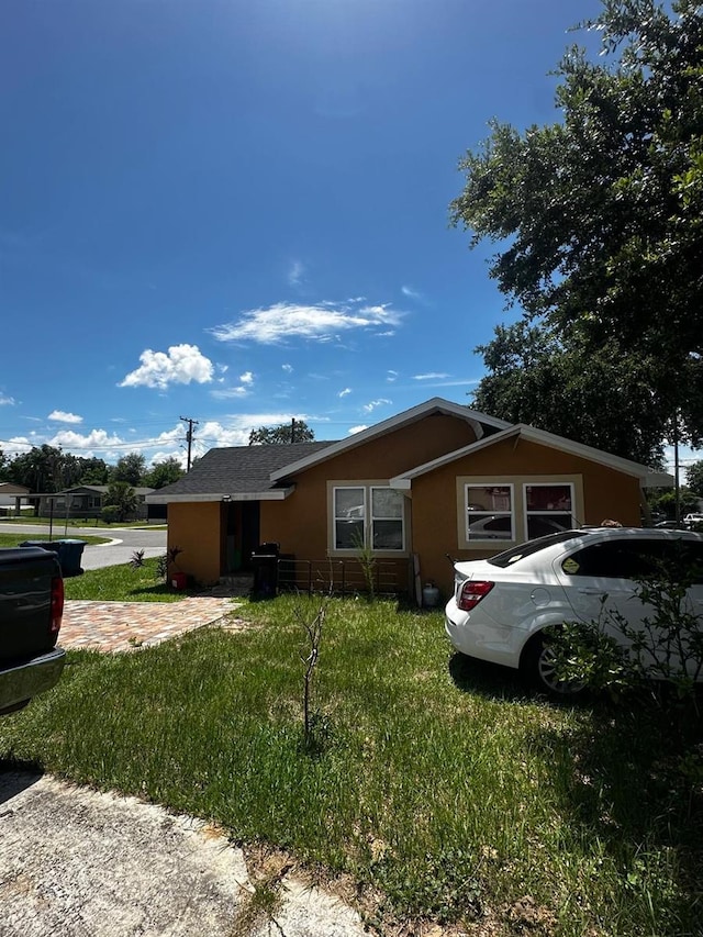 701 N 7th St, Haines City, FL 33844 - view of home's exterior with stucco siding and a yard