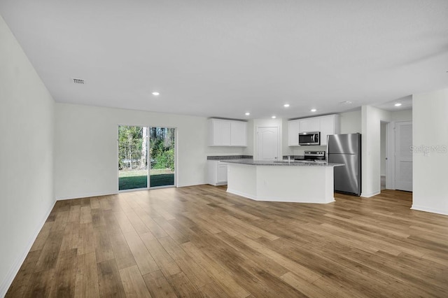 103 Whippoorwill Dr, Palm Coast, FL 32164 - kitchen with stainless steel appliances, light wood-style flooring, recessed lighting, a kitchen island with sink, and open floor plan