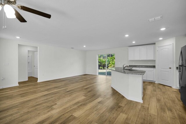 103 Whippoorwill Dr, Palm Coast, FL 32164 - kitchen with ceiling fan, light wood-style floors, open floor plan, white cabinets, and recessed lighting