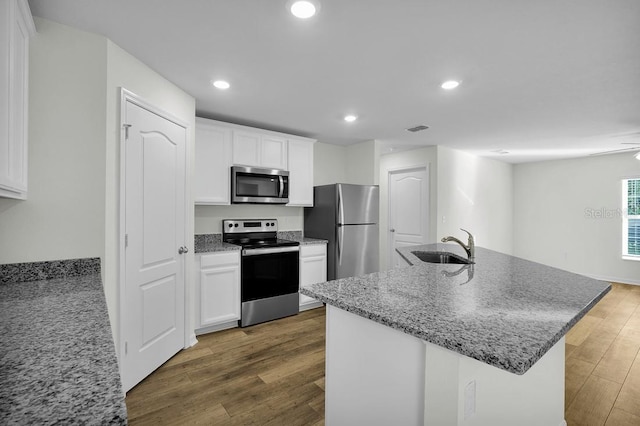 103 Whippoorwill Dr, Palm Coast, FL 32164 - kitchen with appliances with stainless steel finishes, white cabinetry, wood finished floors, light stone countertops, and recessed lighting