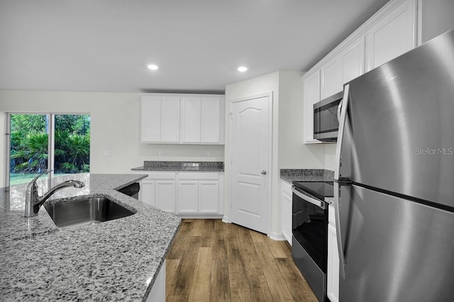 103 Whippoorwill Dr, Palm Coast, FL 32164 - kitchen featuring appliances with stainless steel finishes, dark wood finished floors, recessed lighting, white cabinetry, and light stone countertops
